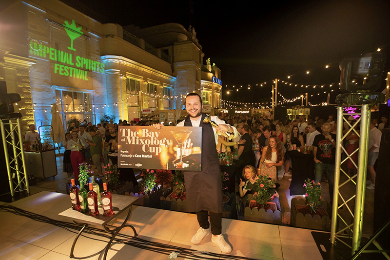 Photo of a bartender triumphantly holding The Bay of Mixology Cup, celebrating his victory at the Imperial Spirits Festival in Opatija, Croatia.